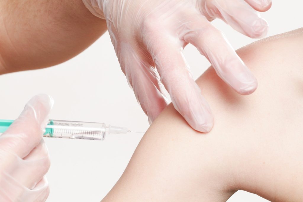 a person gets a vaccine shot in the shoulder